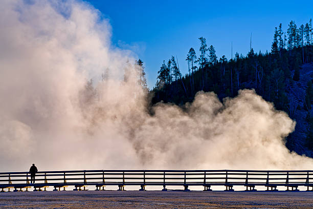 Yellowstone National Park in the state of Wyoming on October 02, 2024:  Man out for early morning sight seeing along the boardwalk by the Grand Prismatic Spring in Yellowstone National Park