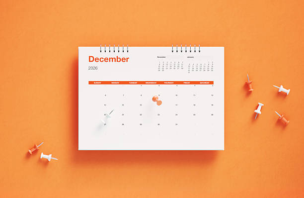 close up of calendar on the orange table background, planning for business meeting or travel planning concept