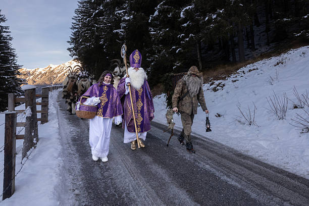 istock Festive procession featuring St. Nicholas and helpers along a snowy mountain road in winter 2226854350
