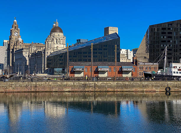 5th March 2022: Looking across Liverpool's Canning Dock at the old Great Western Railway warehouse and office building, built around 1890. The old GWR warehouse and office is beside the Canning Graving docks, which in recent years has undergone urban regeneration. Tate Liverpool is behind the GWR building and behind that is Liverpool's iconic Royal Liver Building.  Canning Dock has a dark history, linked to the transportation of slaves and slave-produced products in the 18th and early 19th century.