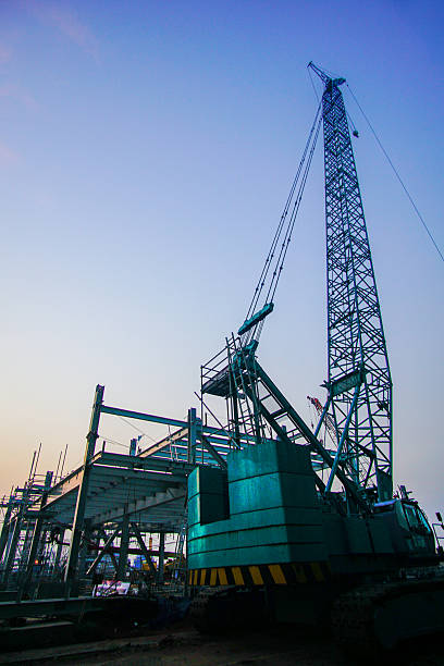 istock Silhouette of towering construction crane against a clear gradient blue sky highlighting industrial machinery and infrastructural development at dusk 2226862464