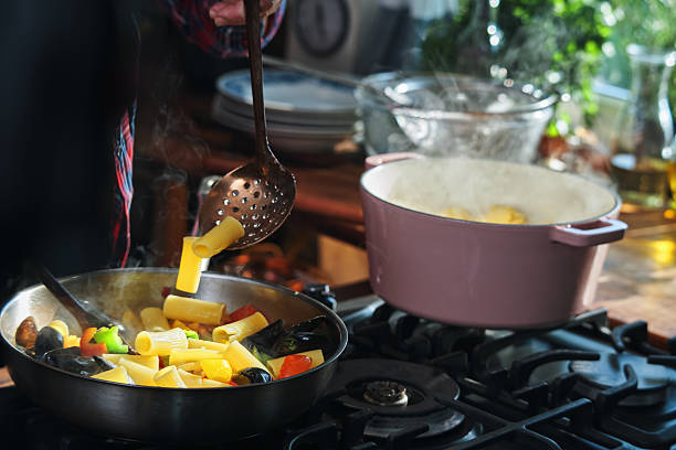 young attractive asian woman cooks in a kitchen,pasta,hands