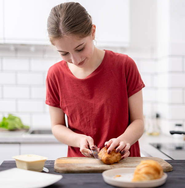 Pretty Young Girl Cuts Croissant