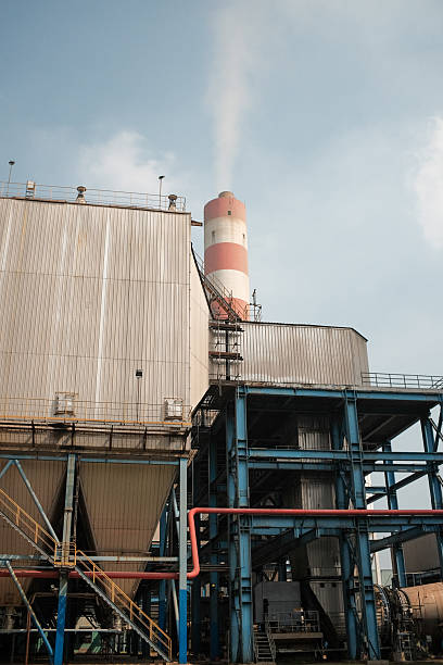 istock Industrial Complex with Chimney Emitting Smoke Against a Cloudy Blue Sky Location 2226863291