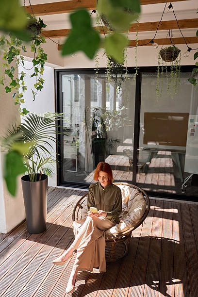istock Young business woman using phone sitting in sunny office. Vertical top view 2226866376