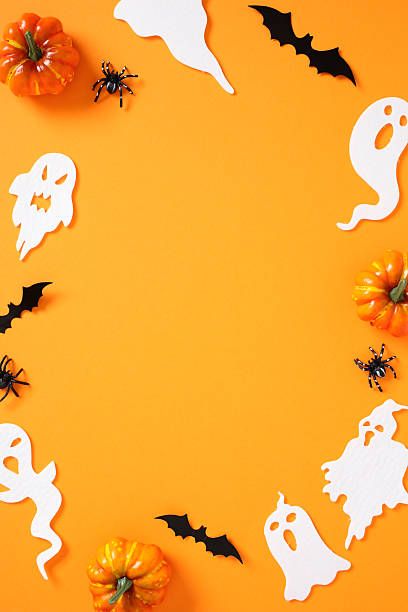 istock Halloween border layout on vivid orange background: pumpkins, bats, ghosts, and spiders frame the scene with festive symmetry. 2226868071