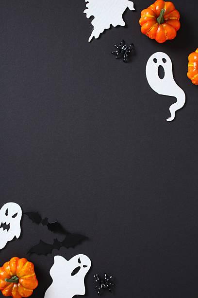istock Halloween border design with playful ghosts, pumpkins, bats, and spiders arranged on black. Center space left empty. 2226868120