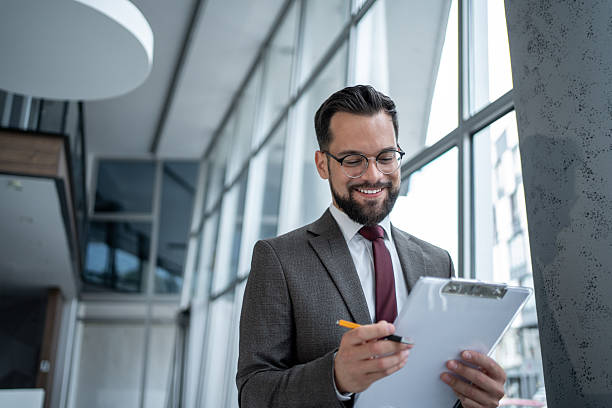 istock Smiling businessman reviewing documents in modern office 2226869169