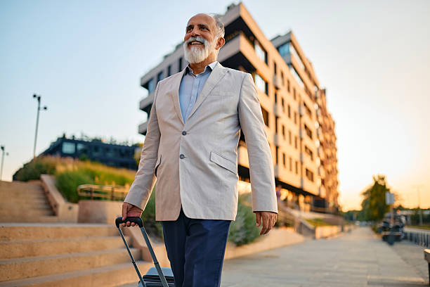 istock Senior businessman walking with suitcase in urban environment 2226872320