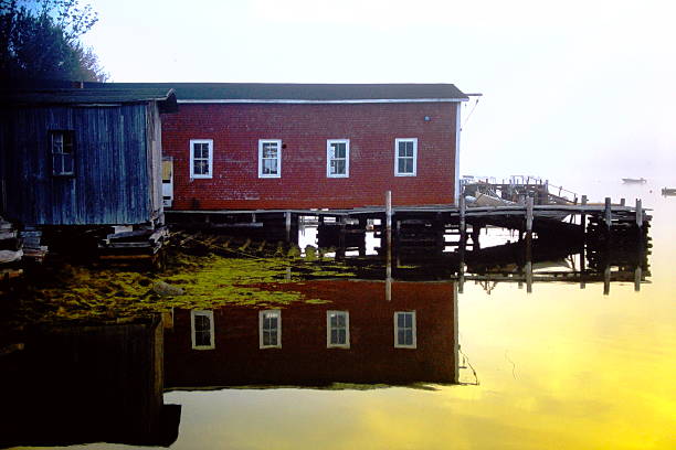 A vibrant fishing village on the coast of Nova Scotia, captured on 35mm slide film in 2001. Brightly painted homes and boats line the harbor, reflecting the charm and character of East Coast life. The subtle grain and rich tones of vintage film add a nostalgic, timeless quality to this maritime scene.