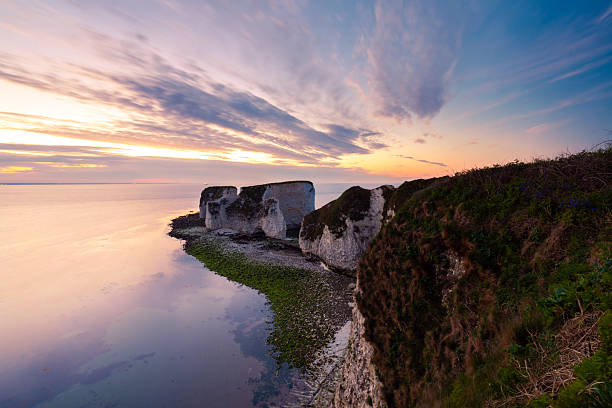 Rocky coastline on Atlantic ocean during sunset at Faroe Islands.