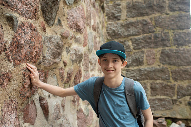 istock boy touches stone wall of medieval castle on excursion 2226877955