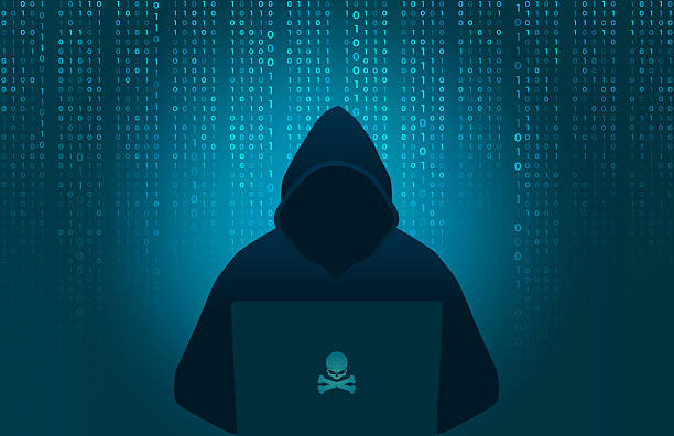istock Hacker wearing hood using laptop computer with glow skull and crossbones logo in dark room on binary code number background 2226879972
