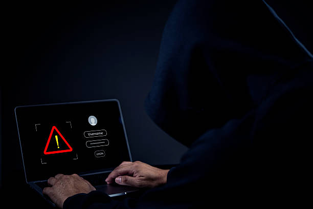 istock Cybersecurity threat, unknown person in dark hoodie typing on computer, digital safety, cybercrime, personal data protection, scam alert, hacking attempt, online security risk. 2226892065