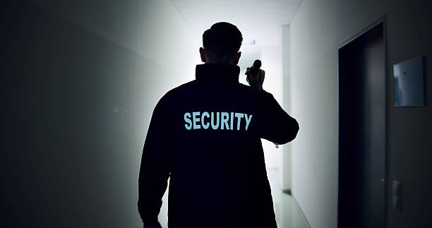 istock Night Warehouse Security Guard Patrols In Uniform With Flashlight 2226896853