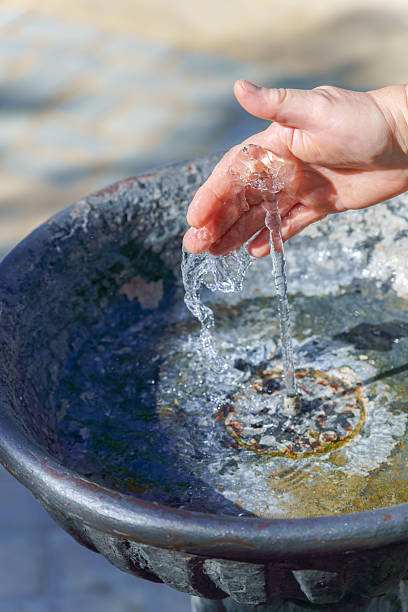 istock Hand refreshing with clean water from public fountain on sunny day 2226898332