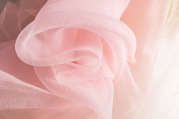 istock chic large waves of pink chiffon fabric. Delicate transparent fabric texture. elegantly twisted silk fabric. Festive background 2226901237
