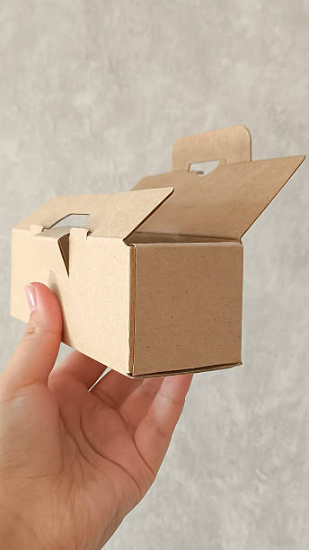 istock female hands holding a small cardboard box on a white background. packaging and delivery concept, top view 2226903515