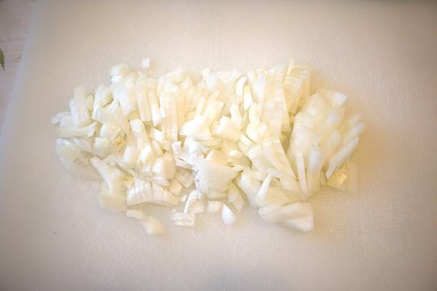 istock Chopped onion on white plastic cutting board, close-up 2226905788