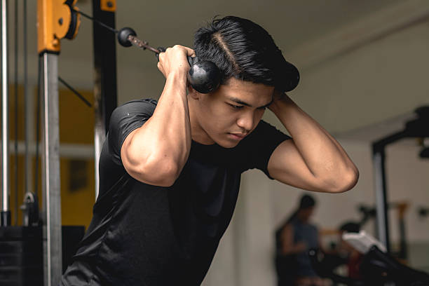 istock A young handsome asian man does standing rope crunches. Core exercises at the gym. 2226906218