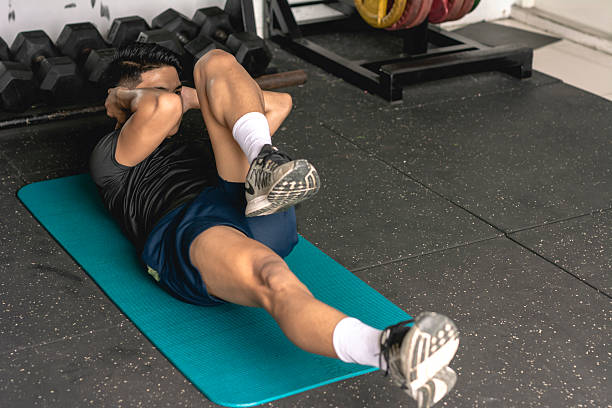 istock A young man doing a set of bicycle crunches on a mat. Abdominal and core workout exercise at the gym. 2226906755