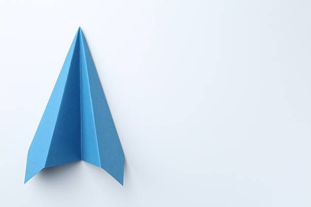 istock One handmade light blue paper plane on white background, top view. Space for text 2226910601