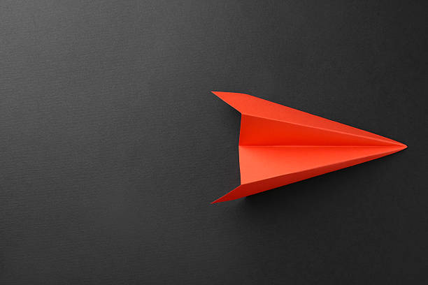 istock One handmade orange paper plane on grey background, top view. Space for text 2226910655