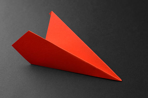 istock One handmade orange paper plane on grey background, closeup 2226910669