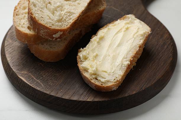 istock Fresh bread with butter on white table, closeup 2226911264