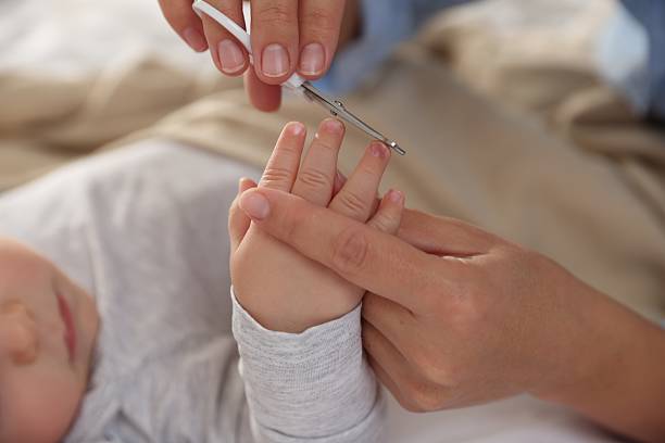 istock Mother cutting her cute little baby's nails on bed, closeup 2226911421