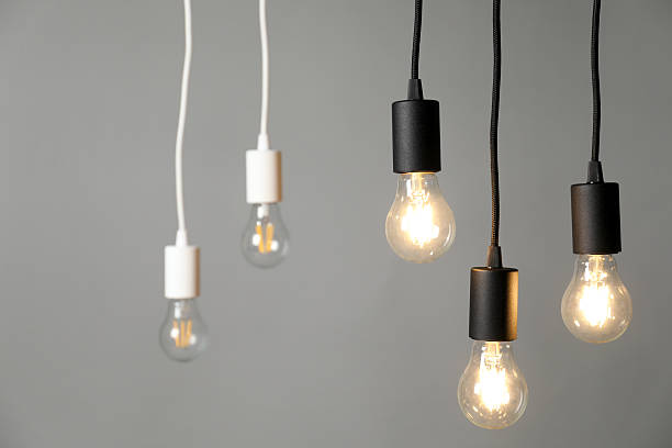 istock Light bulbs hanging on cords against grey background, selective focus 2226911810