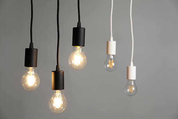 istock Light bulbs hanging on cords against grey background, selective focus 2226911819