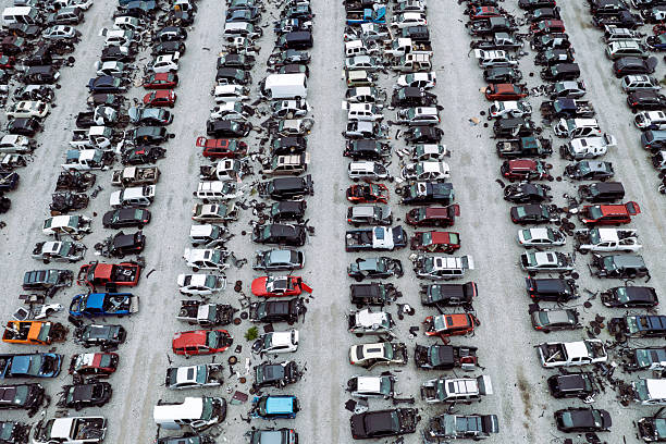 Aerial view of rows of crashed cars at a large car junkyard in the USA. It serves as a warehouse for used spare parts and a place for recycling old cars.