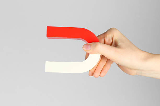 istock Woman with horseshoe magnet on grey background, closeup 2226912975