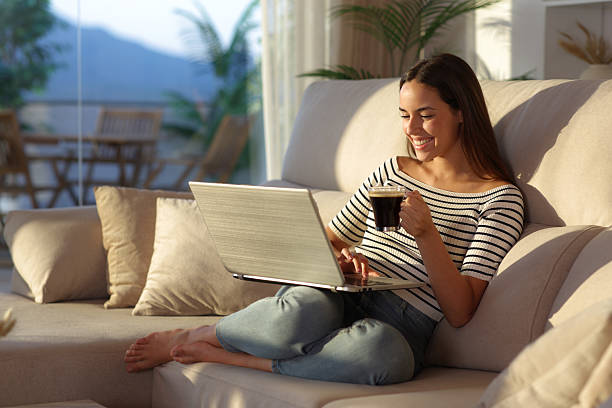 istock Happy woman drinking coffee using laptop at home 2226913125