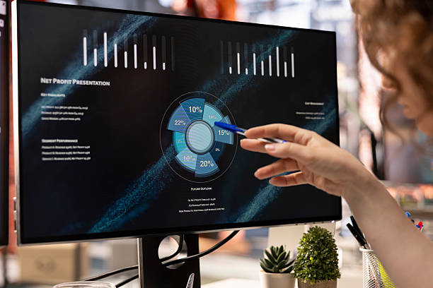 Young adult transcribing financial company growth graphs on PC screen