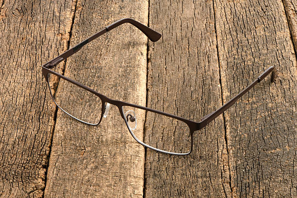 Reading glasses on dark wooden background. High resolution photo. Full depth of field.