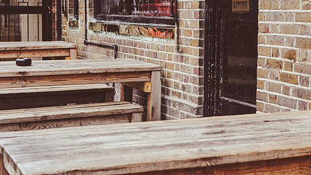 istock Empty wooden pub tables outside in warm daylight ready for guests and drinks 2226917715