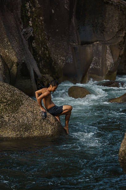 istock Young man relaxing by the river in the rainforest 2226920032