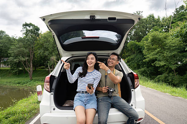 istock Couple sitting in a car trunk, enjoying the view 2226923162
