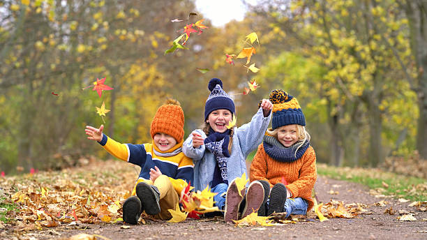 istock Autumn Delight: Kids Tossing Colorful Leaves in Joy 2226924426