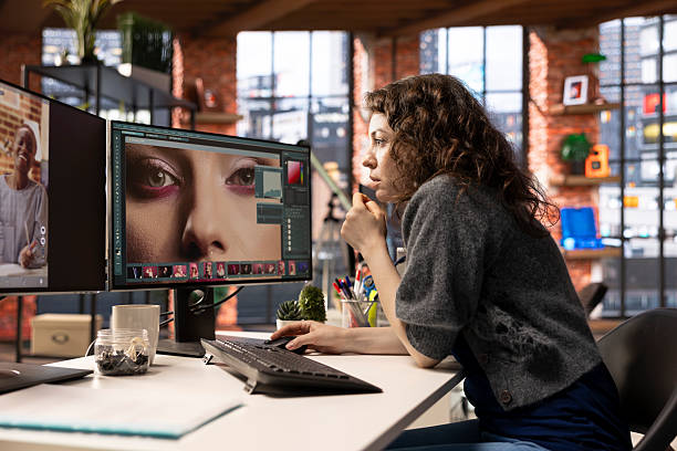 istock Female editor designer retouches photos on dual monitors desktop 2226926247