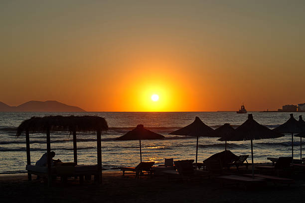 Albania, Vlora, July 11, 2025 - Image taken at sunset from the city's waterfront with the sun setting over the Adriatic and Sazan Island