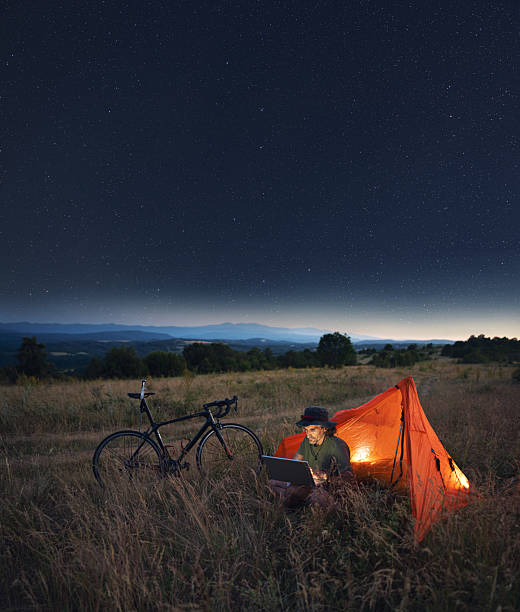 istock Bicycle Adventure Night Tourism. Man Camping Outdoors Using Laptop 2226928339
