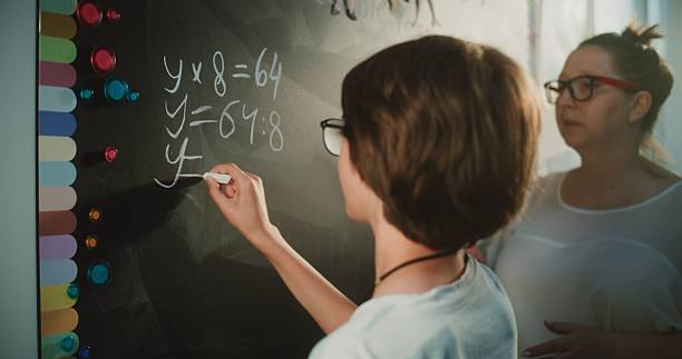 istock Primary School Student Solving Mathematical Equation Writing on the Board with Chalk 2226938082