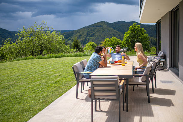 istock Friends Sharing Summer Meal On Modern Patio With Mountain View And Dramatic Sky 2226938255