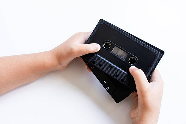 istock Hands holding vintage audio cassettes on white background 2226945320