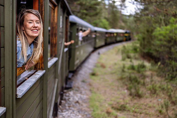 istock Woman Smiling While Enjoying Scenic Train Journey in Forested Landscape 2226950540
