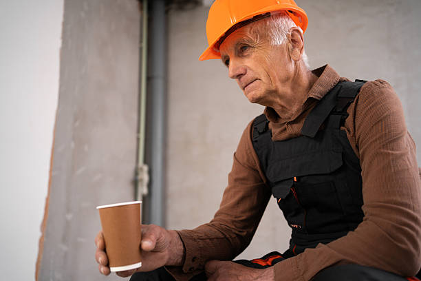 istock Elderly Builder in working uniform drinking coffee sitting at construction site. building and industry 2226951771