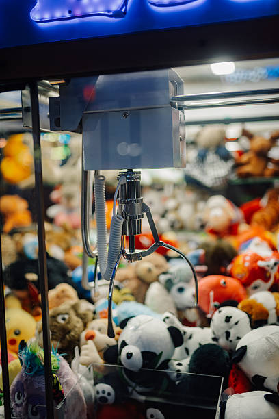 istock Claw crane machine picking up plush toys in arcade game 2226956601